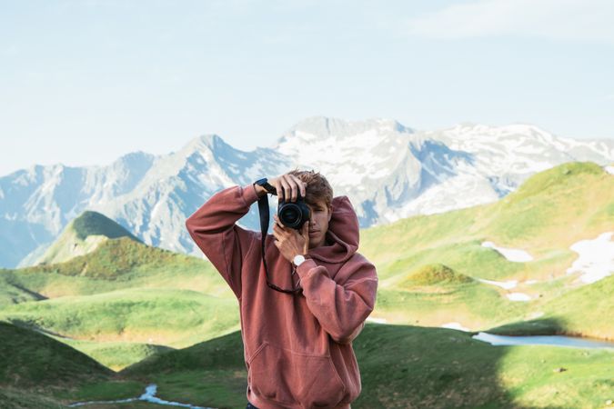 Man taking photo in mountain landscape