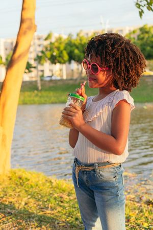 girl looking to the side while walking in a park during vacation. Summer concept.