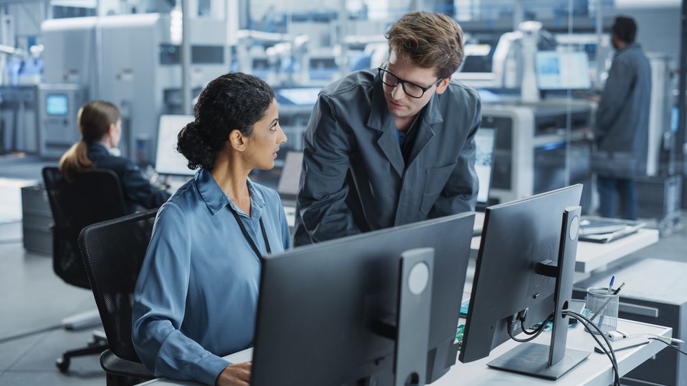 White Man and Hispanic Woman Having Conversation at Industrial Facility.