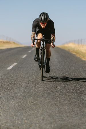 Racer riding a bicycle on the empty road