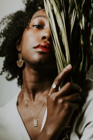 Woman in light shirt holding green plant