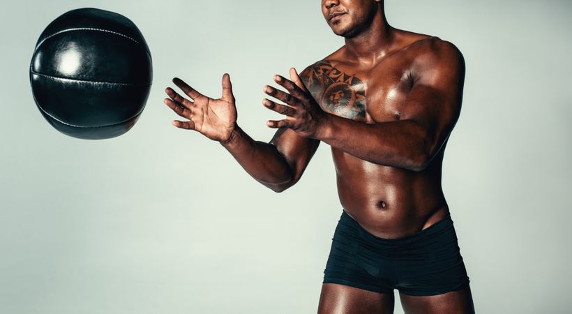 Healthy young man exercising with medicine ball