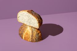 Homemade bread with poppy seeds on a purple background