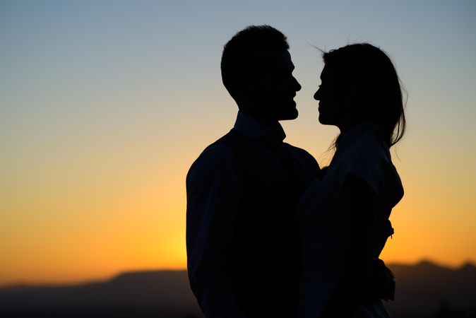 Outline of male and female couple at sunset, copy space