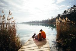 Couple relaxing on the pier of a lake