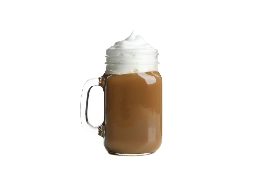 Iced coffee with poured cream isolated on plain background