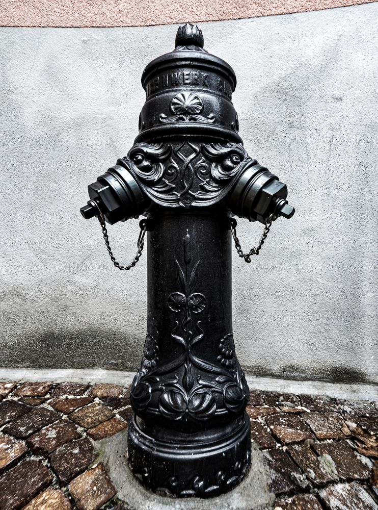 Old fire hydrant, water column on the street in Sion