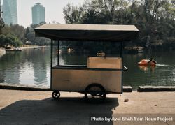 Empty vendor cart next to pond in city park 41B8lb