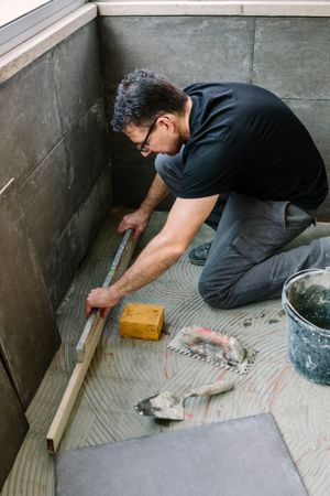 Bricklayer checking floor with a level
