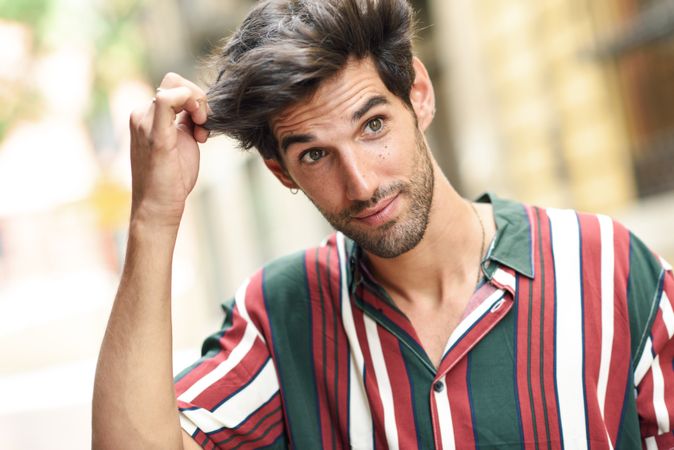 Portrait of curious dark haired man standing outside