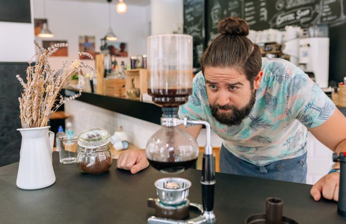 Barista skillfully brewing specialty coffee with Japanese siphon coffee maker