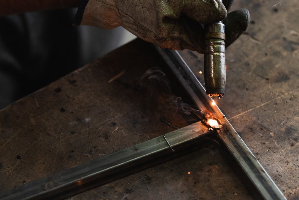 Crop master welding metal pieces at workbench