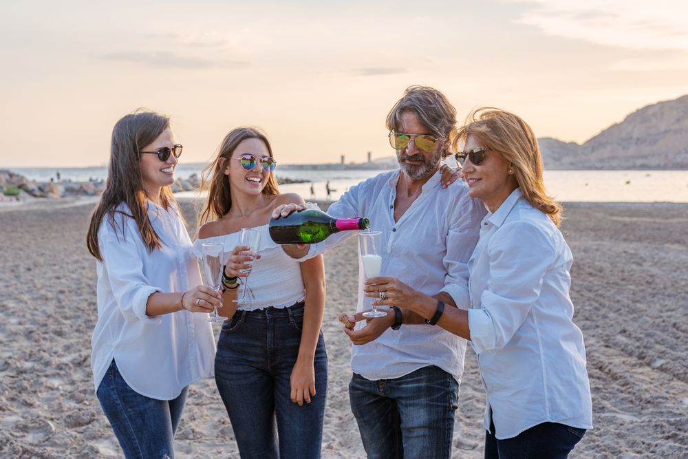 Happy family drinking wine on beach