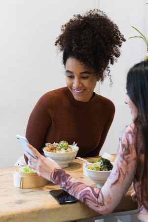 Smiling multiethnic women eating in restaurant