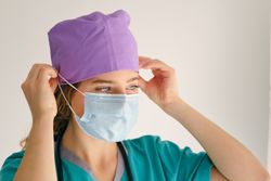 Young woman in scrubs with mask