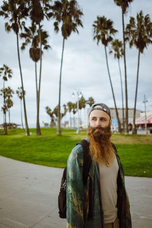Bearded traveler on pavement in city