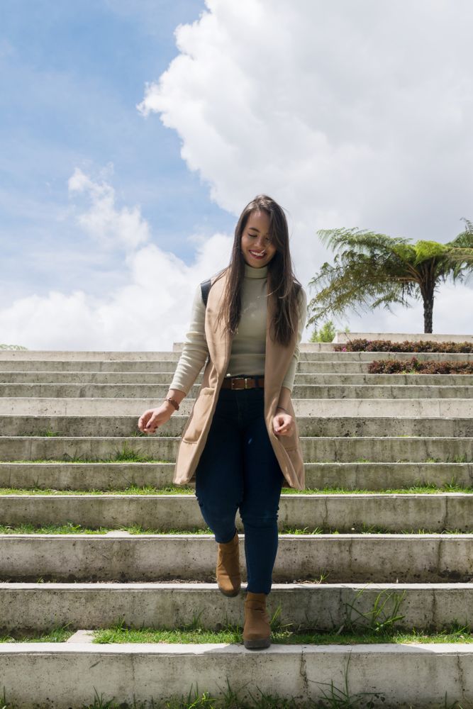 Woman in warm clothes walking down stone stairs