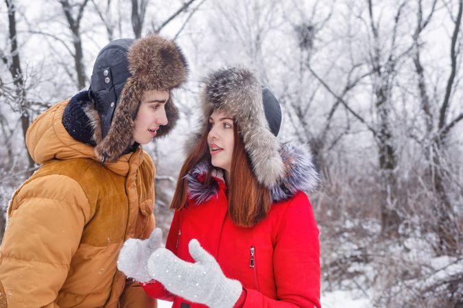 Teenage couple talking in wintery forest
