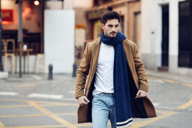 Man in winter clothes walking through Spanish town