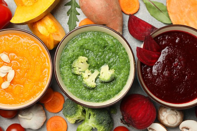 Close up of three colorful soups, top view