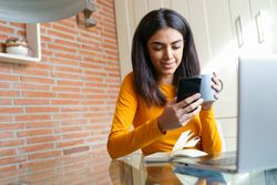 Female sipping coffee while working in home office