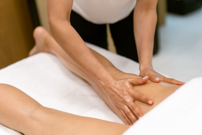 Masseuse giving a leg massage to a woman