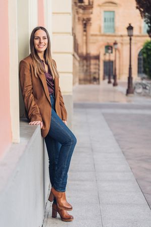 Pleased female in stylish outfit on street smiling away