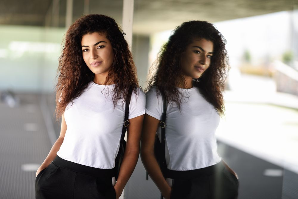 Arab woman leaning against window of corporate office building