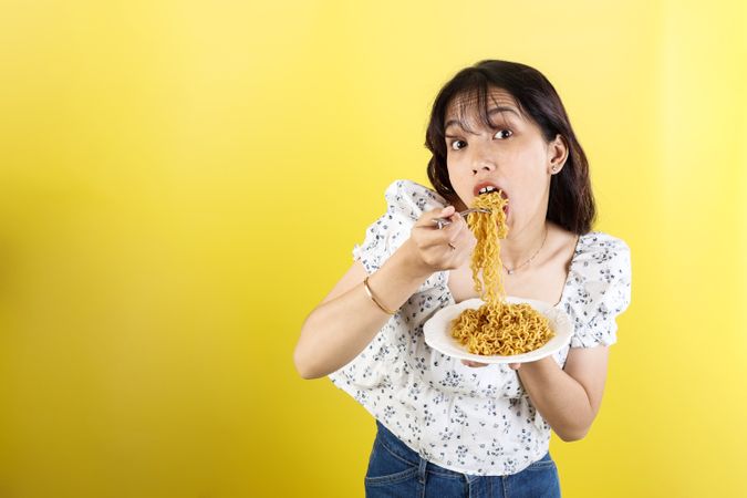 Happy Asian Woman Eating Instant Noodles