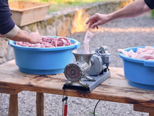 Crop guys grinding meat with fat in nature