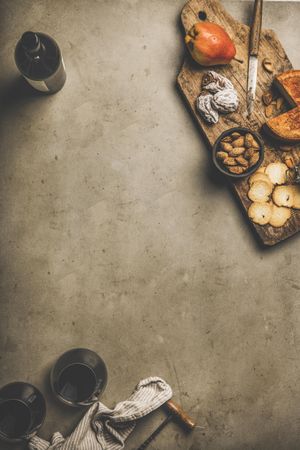 Cheese plate with glasses of red wine, bottle, with copy space in between