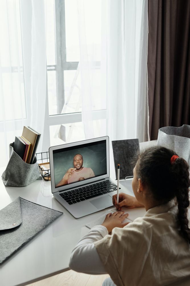 Girl using laptop and writing a note on a paper