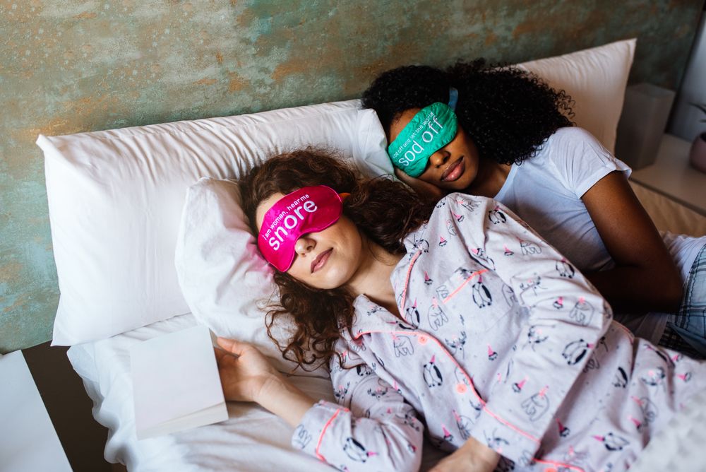 friends relaxed sleeping in bed with blindfold at home