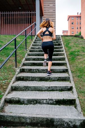 Female athlete climbing stairs outdoors