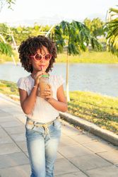 Girl walking in the park while drinking juice