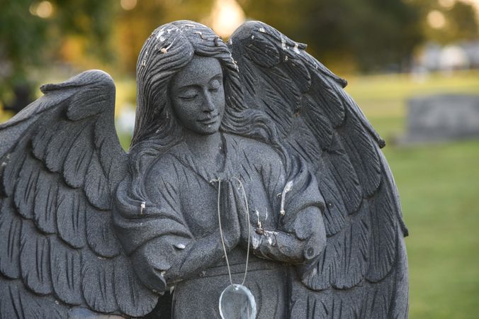A praying angel statue in a cemetery