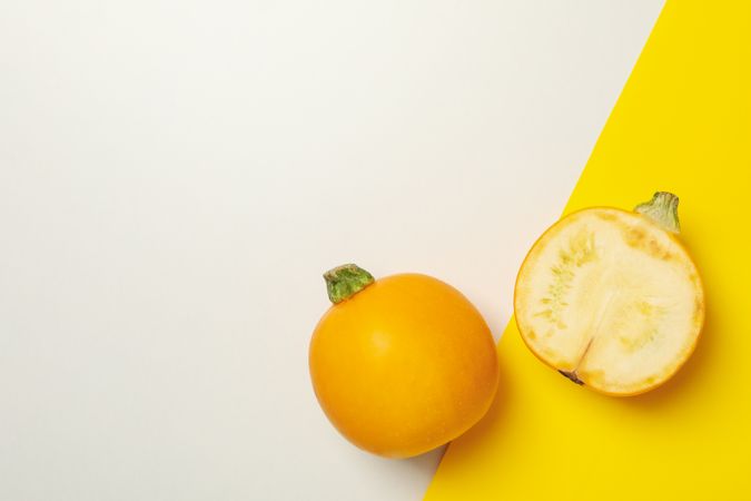 Round zucchini and half on two tone background