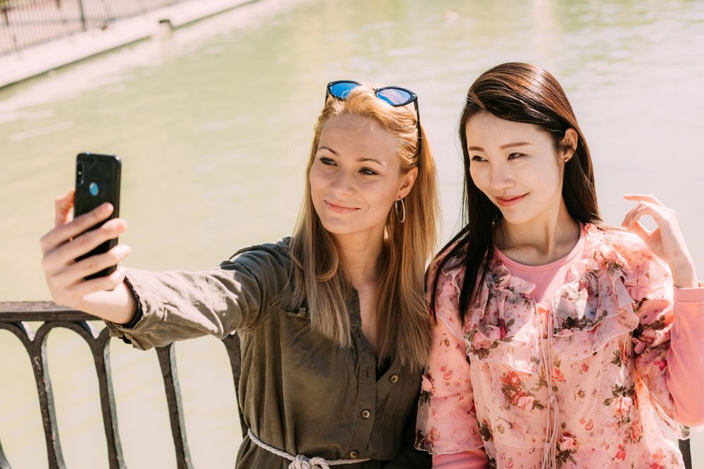 Multiethnic friends taking a selfie photo on embankment