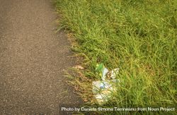 Trash on the side of the road in the grass 5pL9O5