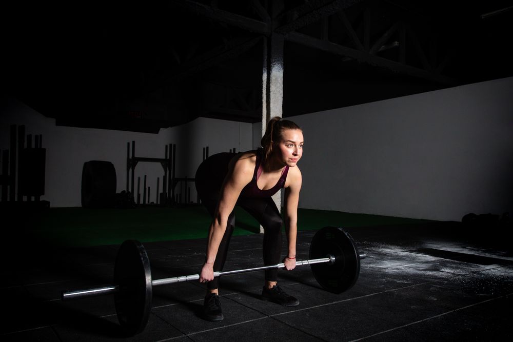 Woman lifting barbell in gym