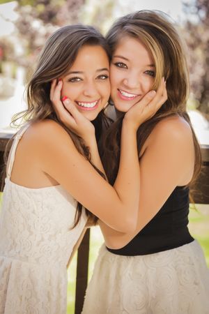 Two female friends standing in outside garden
