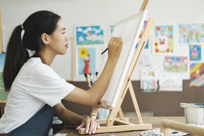 Crafting Inspiration: Female Artist Sketching and Painting in Workshop
