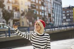 female in red beret taking selfie