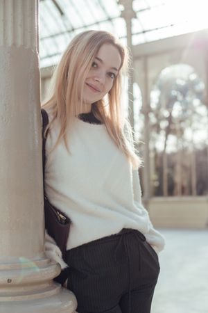 elegant woman leaning in a post