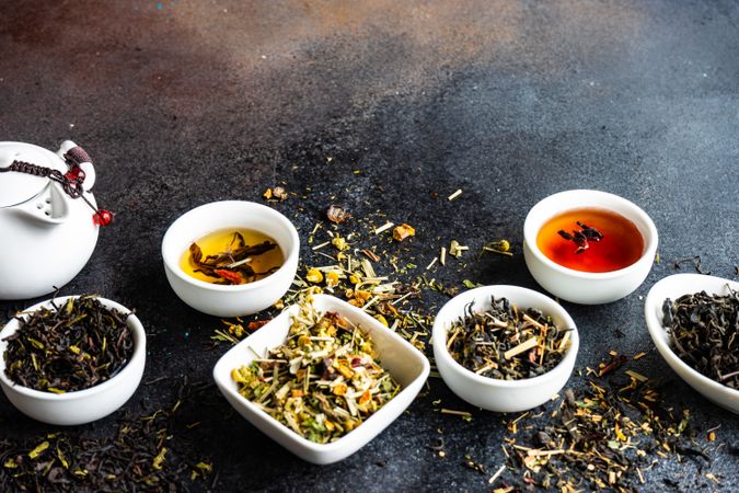 Loose leaf teas in bowls with tea pot and cup