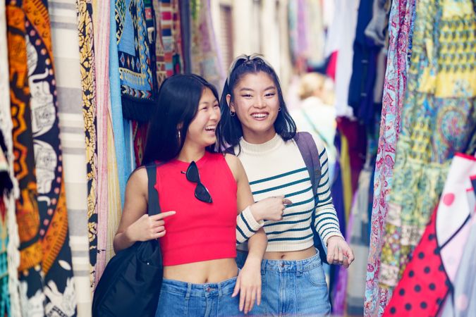 Asian female shopping choosing clothes in outdoor market