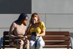 Cheerful multiethnic women looking through photos together