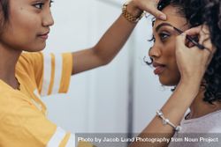 Makeup artist preparing model for a photo shoot 56yrz0