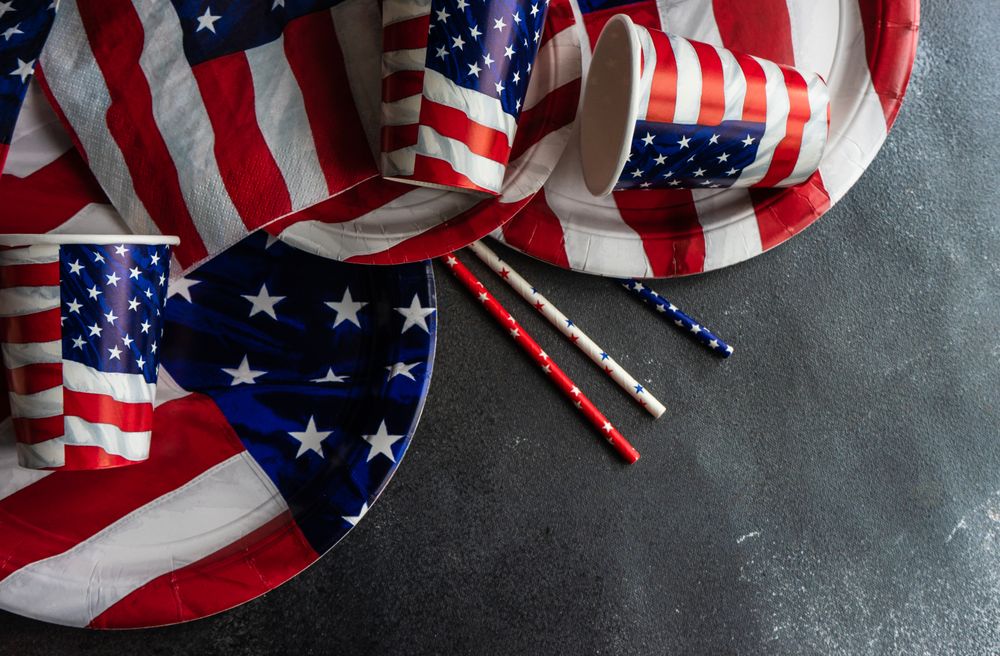 American flag plates and cups on dark table with space for text