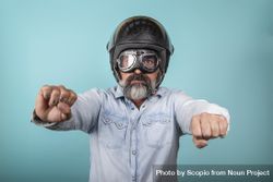 Portrait of man with helmet and glasses pretending to ride a motorcycle in studio 4NlWr0